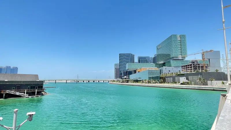 Glass towers on Al Maryah Island across turquoise water in Abu Dhabi