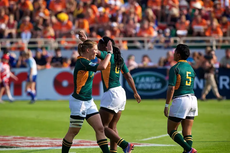 Two South African players embracing on the pitch at the Dubai Rugby Sevens in 2012