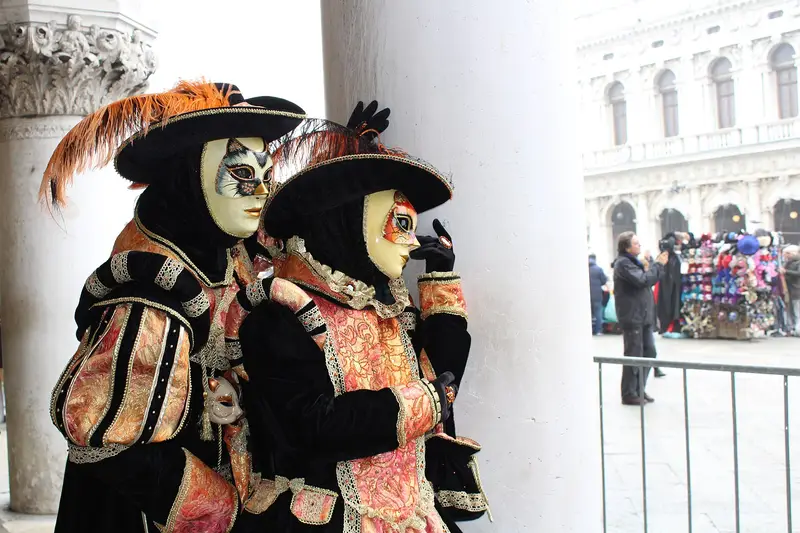 Two people in ornate costumes and masks at the Venice Carnival