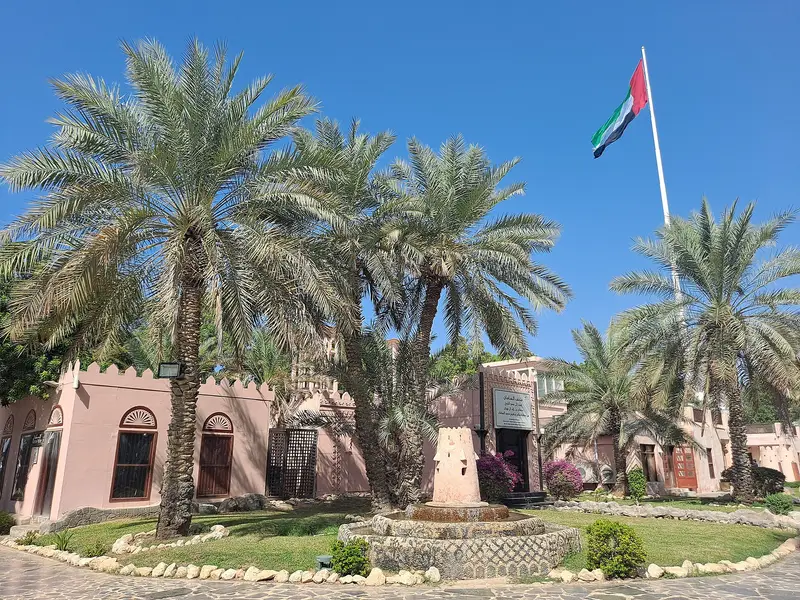 Date palms and the UAE flag at the Heritage Village in Abu Dhabi