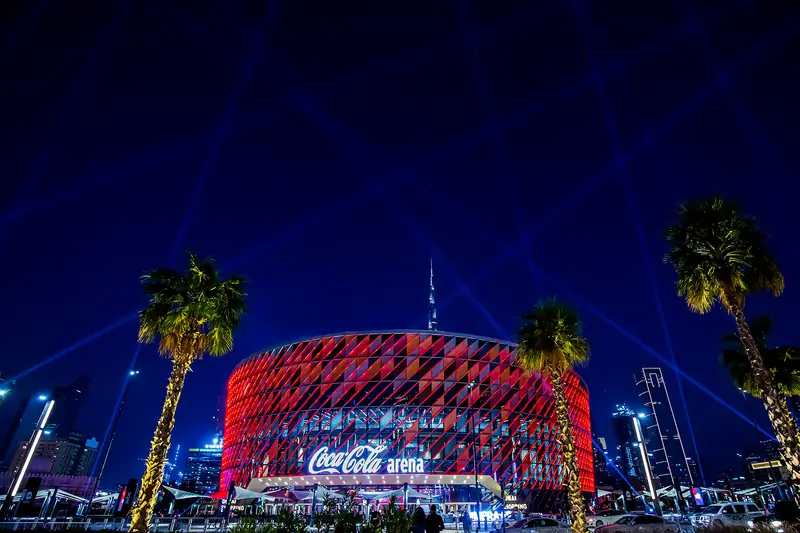 Coca-Cola Arena in Dubai lit in red with laser beams at night