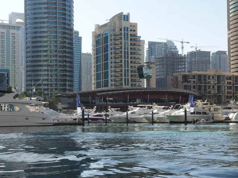 Motor yachts moored at the Dubai Marina Yacht Club below high rise towers