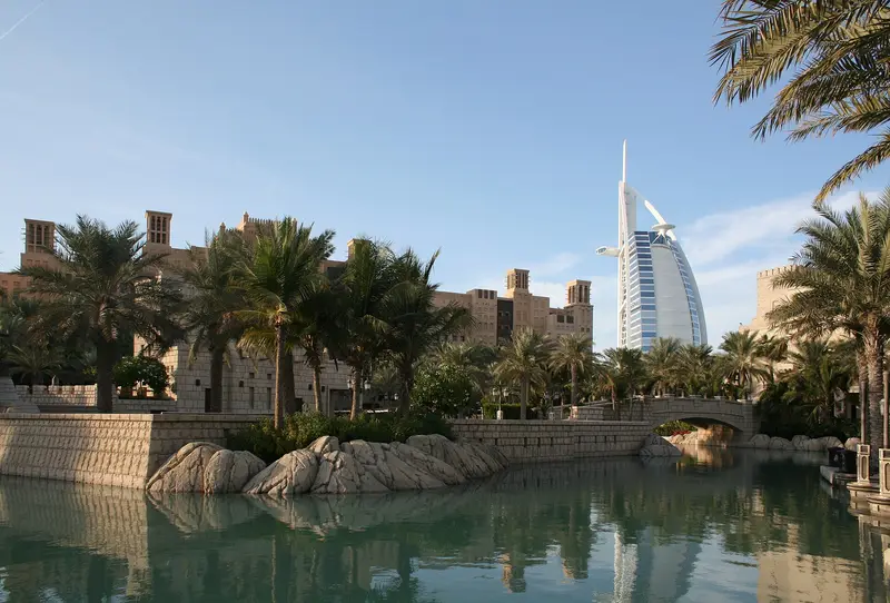 Waterway at Madinat Jumeirah in Dubai with palms, old-town style buildings and the Burj Al Arab beyond