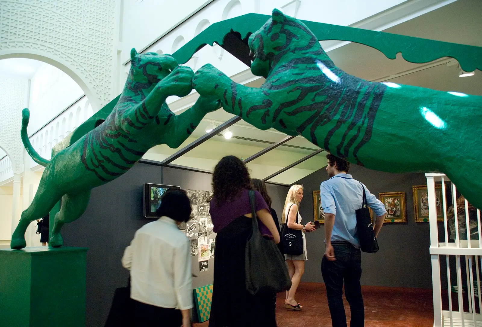 Visitors looking at a green tiger sculpture installation at the Sharjah Biennial